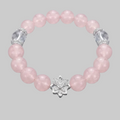 Pink beaded bracelet with silver flower clasp on a gray background