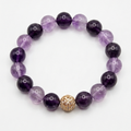 Purple beaded bracelet with a gold clasp on a white background