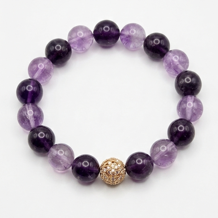 Purple beaded bracelet with a gold clasp on a white background