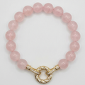 Pink beaded bracelet with a gold clasp on a white background