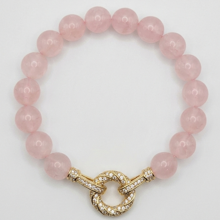 Pink beaded bracelet with a gold clasp on a white background