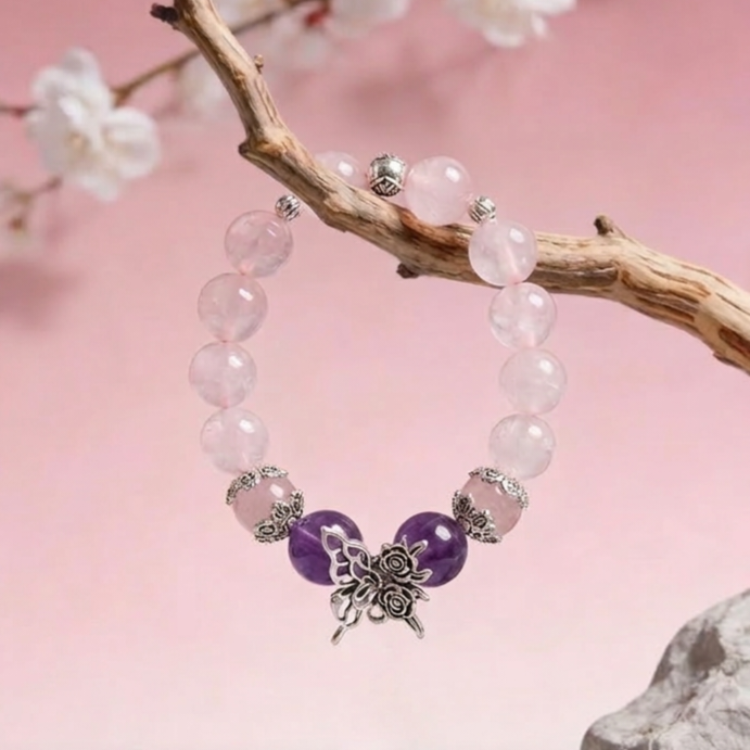 Beaded bracelet with purple and white beads on a branch with flowers and pink background