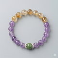 Beaded bracelet with purple, gold, and green beads on a light gray background