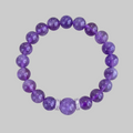 Purple beaded bracelet with a silver accent on a gray background