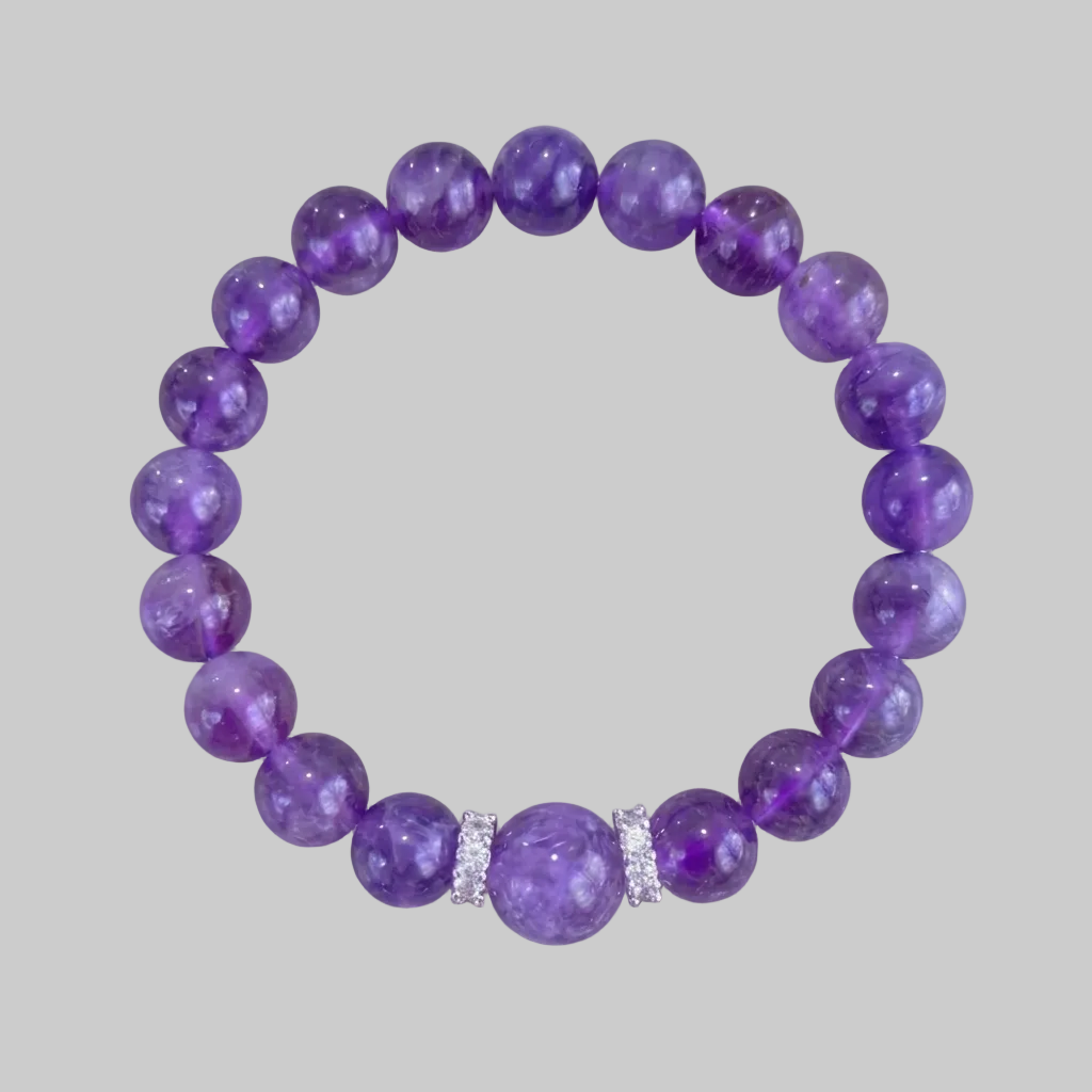 Purple beaded bracelet with a silver accent on a gray background