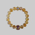 Citrine gemstone bead bracelet with amethyst Om centrepiece bead in gold filigree and a star-shaped clasp with iridescent blue cabochon