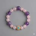 Bracelet with pink and purple beads and a gold clasp on a gray background