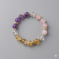 Beaded bracelet with purple, pink, clear, and gold beads on a gray background